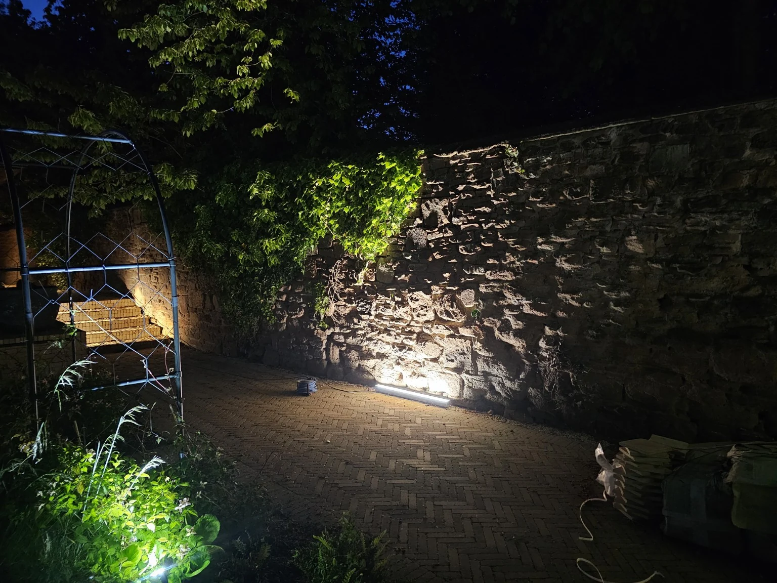 Warm lighting grazing natural stonework and revealing the texture