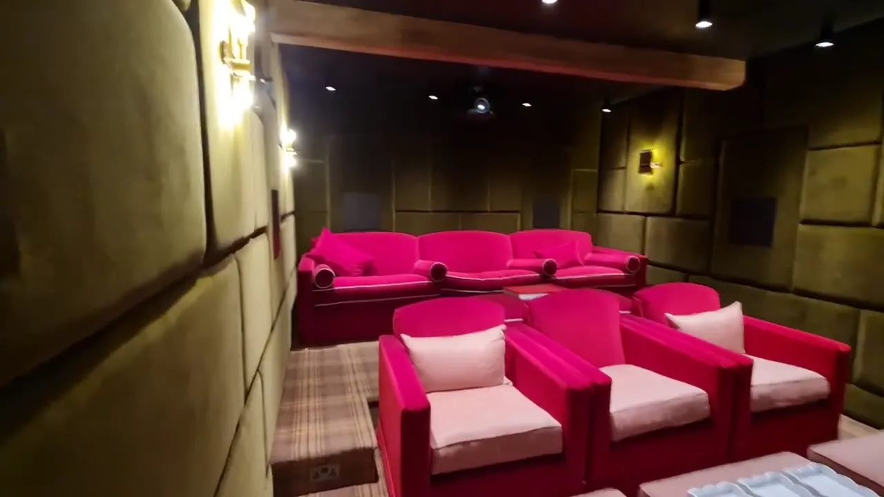 The private cinema with oversized red seats facing the screen