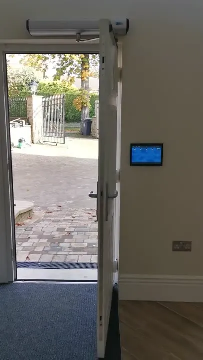 A composite front door held open by its automatic operator