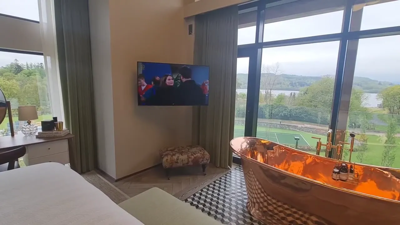 A master suite with a copper bath and a TV on a motorised mount