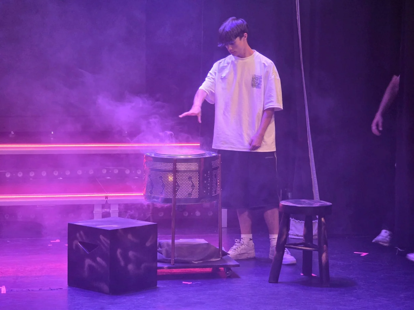 Performer on stage beside the illuminated firepit during Made for Stage UK Ltd’s We Will Rock You